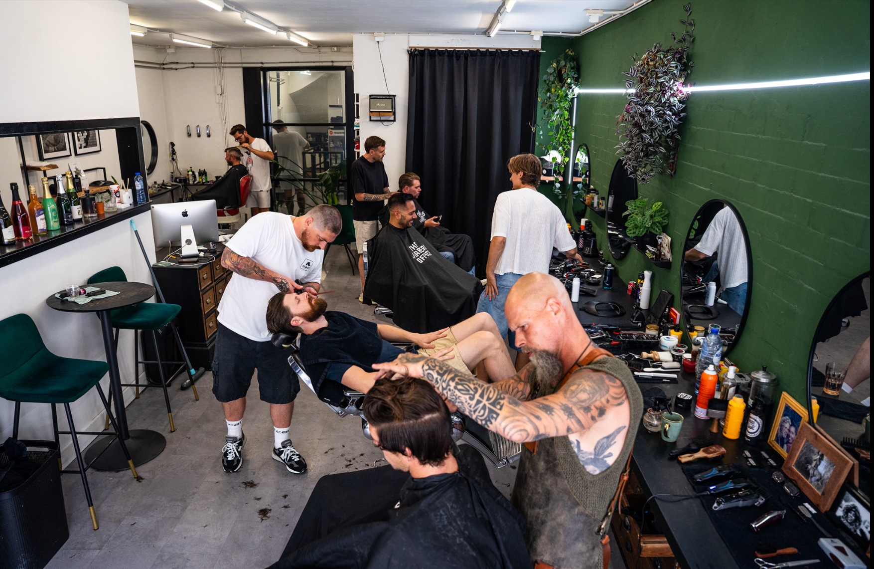 Man shaving customer beard